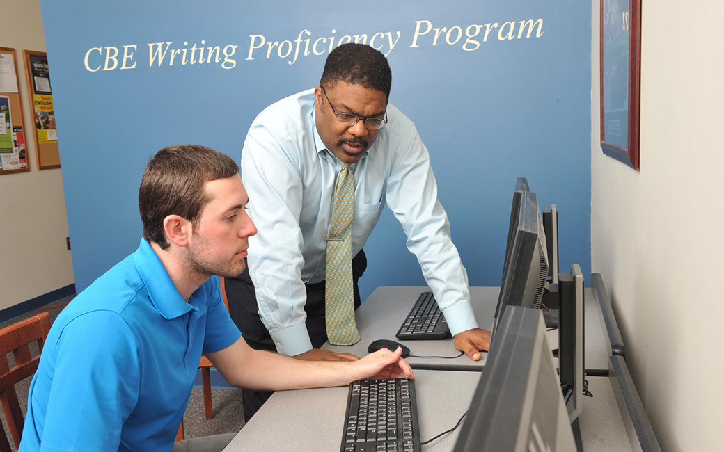 Professor helps a towson university college of business and economics student with a writing assignment in the CBE Writing Lab