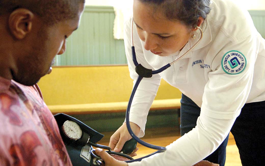 towson university nursing student takes blood pressure reading of an african american man