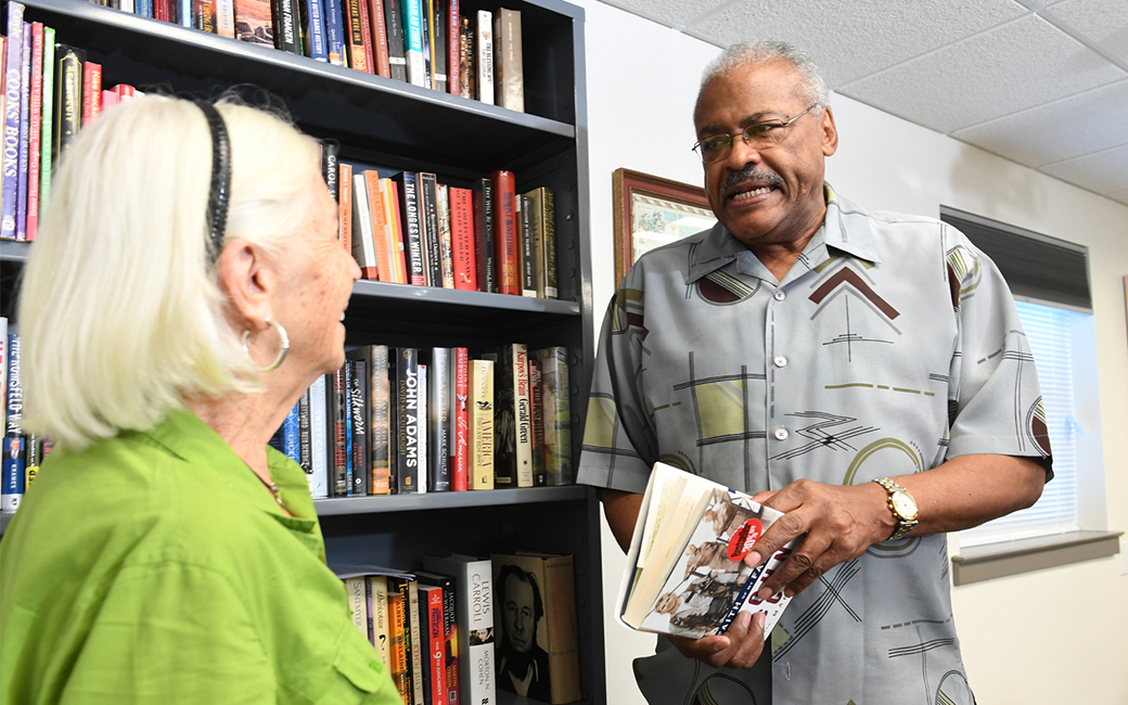 caucasion woman speaking to african american man during an osher book club meeting