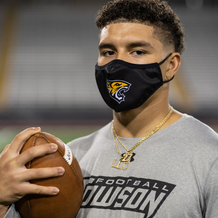 SJ Brown holding a football and wearing a mask