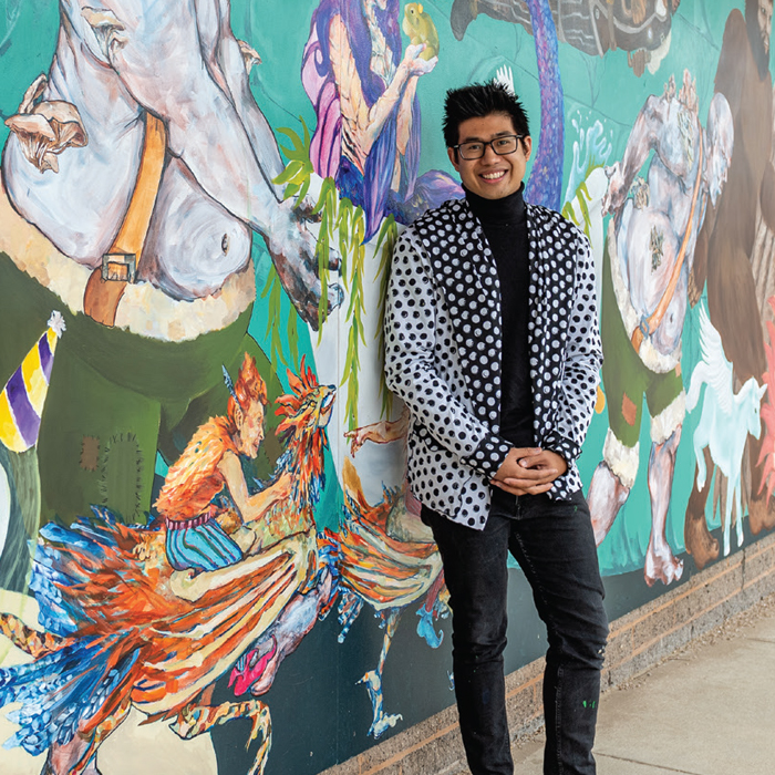 Color image of Justin Nepomuceno '17 standing in front of a mural