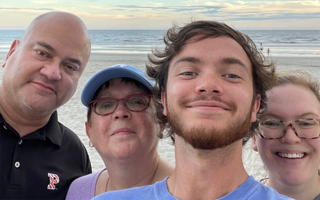 Aneil Mishra and his family pose for a selfie in front of the ocean