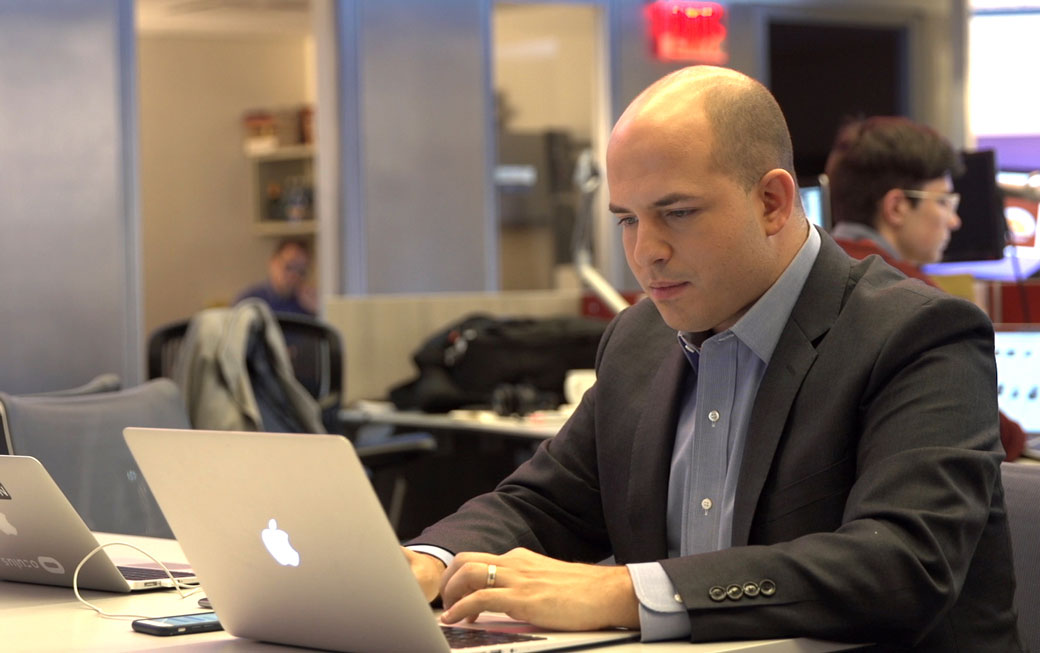 Towson University alumnus Brian Stelter '07 works on a story inside the CNN newsroom. Stelter hosts the CNN show "Reliable Sources," which won the Walter Cronkite Award for Excellence in Television Political Journalism.
