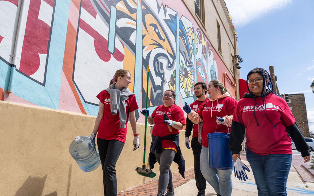 students walk along Towson University mural in Uptown Towson