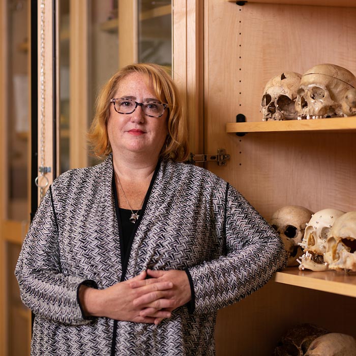 Dana Kollmann portrait next to shelf with skulls