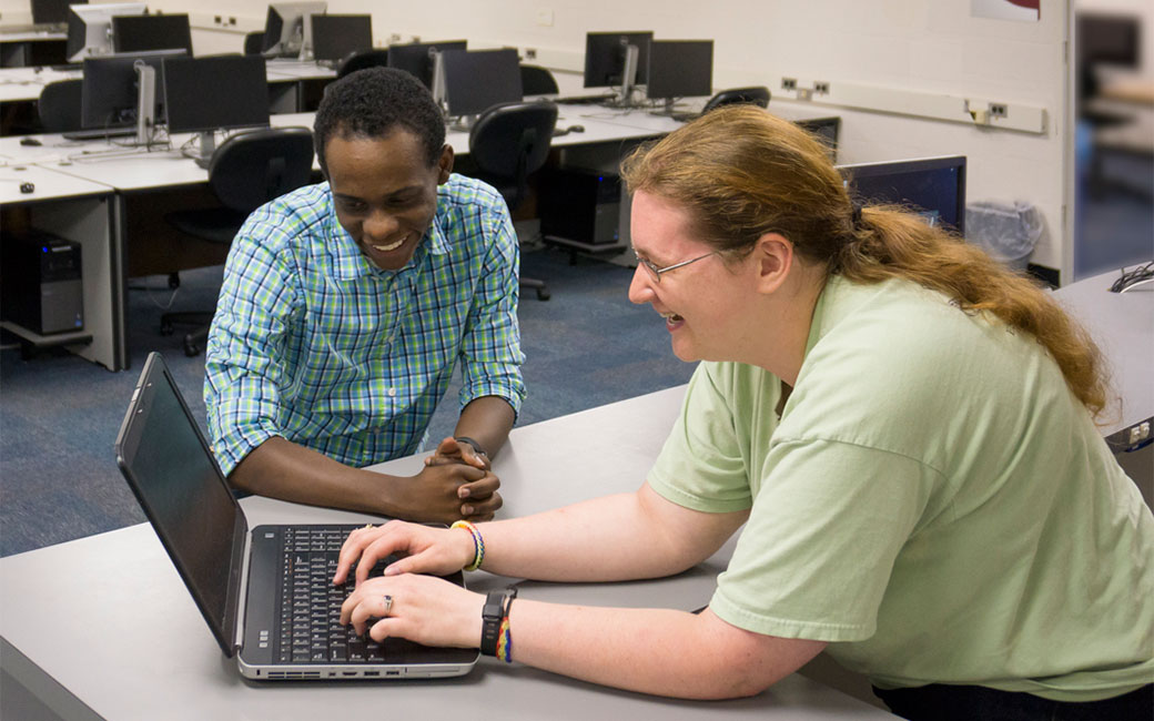 SCS staff help a student troubleshoot a laptop problem