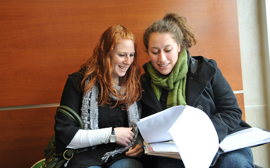 An image of two students looking inside a binder