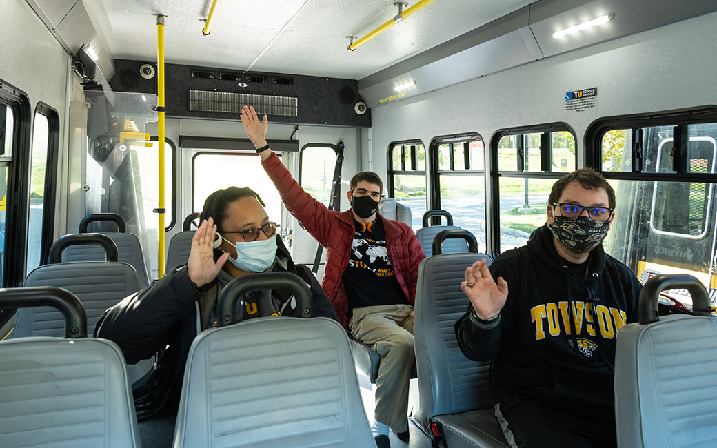 ADS registered students in the paratransit shuttle waving at the camera
