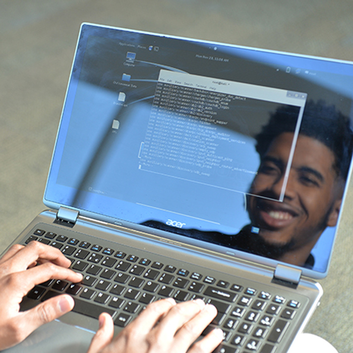 male student face reflected in laptop screen