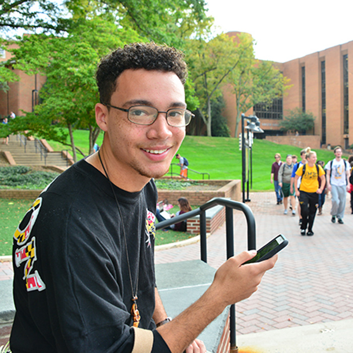 TU student holding smartphone near Freedom Square