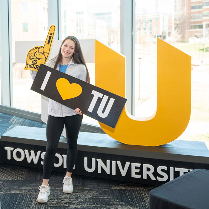 student with TU sign
