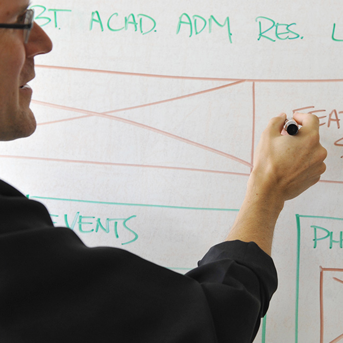 TU employee working on a whiteboard