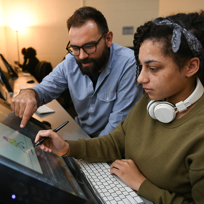 TU mentor with student working on computer