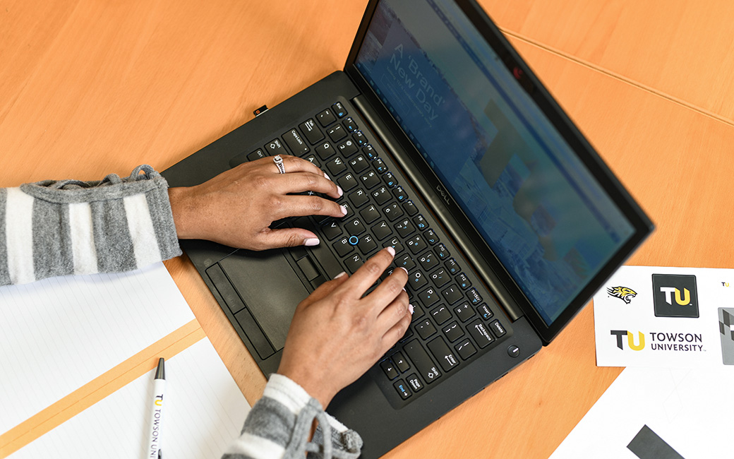 A TU employee writing an email on a laptop