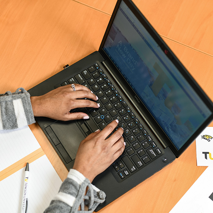 Staff member composing email on a laptop