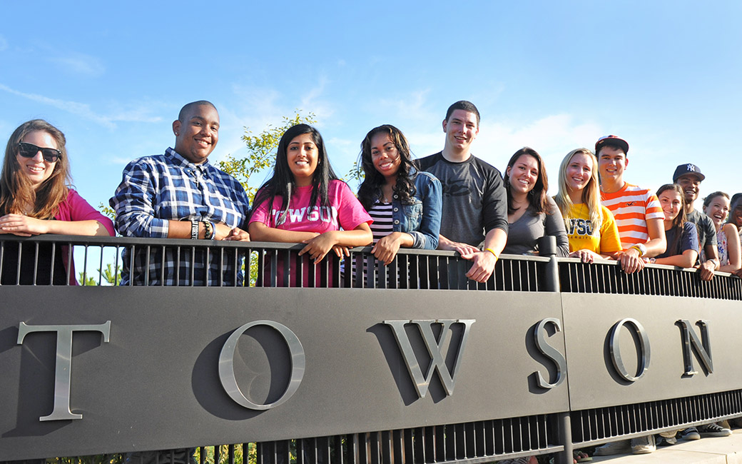 Students standing on bridge that says Towson
