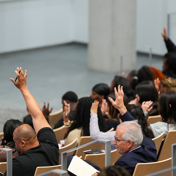 Members of a TU audience at a speaking event raising their hands