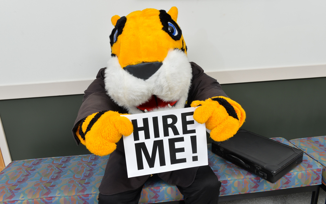 Doc the Tiger with a "Hire Me!" sign