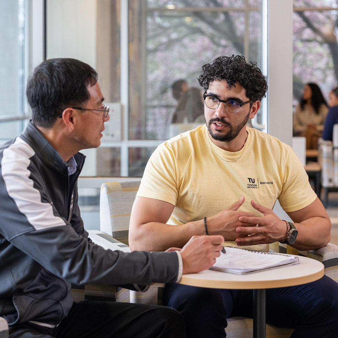 Marketing faculty talks with business student