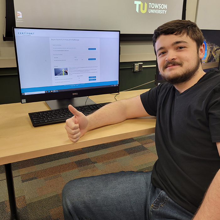 student poses in front of computer