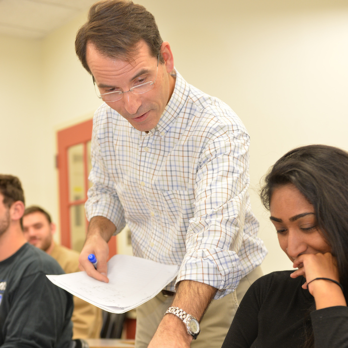 towson university economics professor assists a student in class