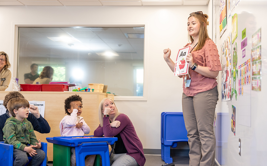 student teacher teaching sign language to children