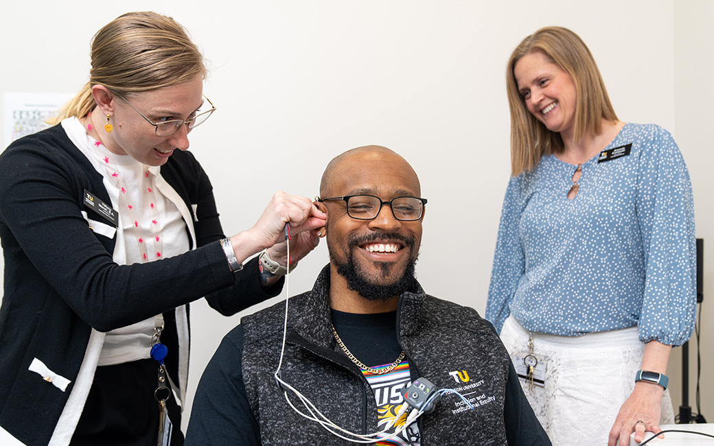 Student and faculty testing a client's hearing