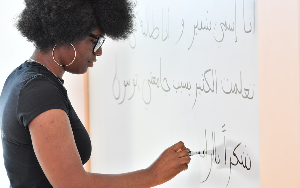 Chenise Calhoun writing in Arabic on board