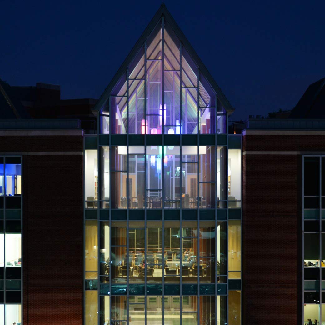 CLA building with the lights on against a dark blue night sky