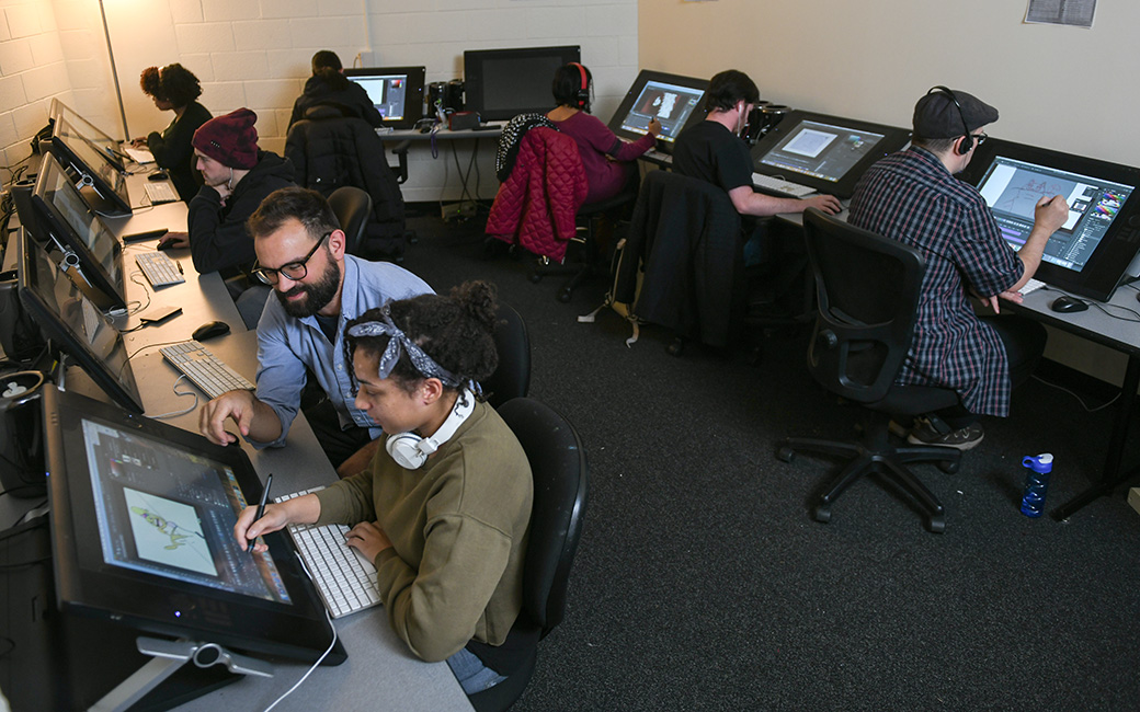 digital art and design computer labs with faculty member (male) and students (females and males)