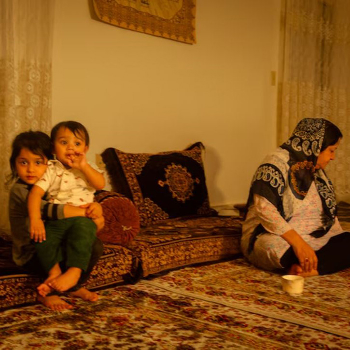 Nazifa, an Afghan refugee, spends time with her young grandchildren at her family's Baltimore apartment. While Nazifa says she appreciates the opportunities in the U.S., she has been surprised by the degree of crime and other city problems. (Mariam Alimi)