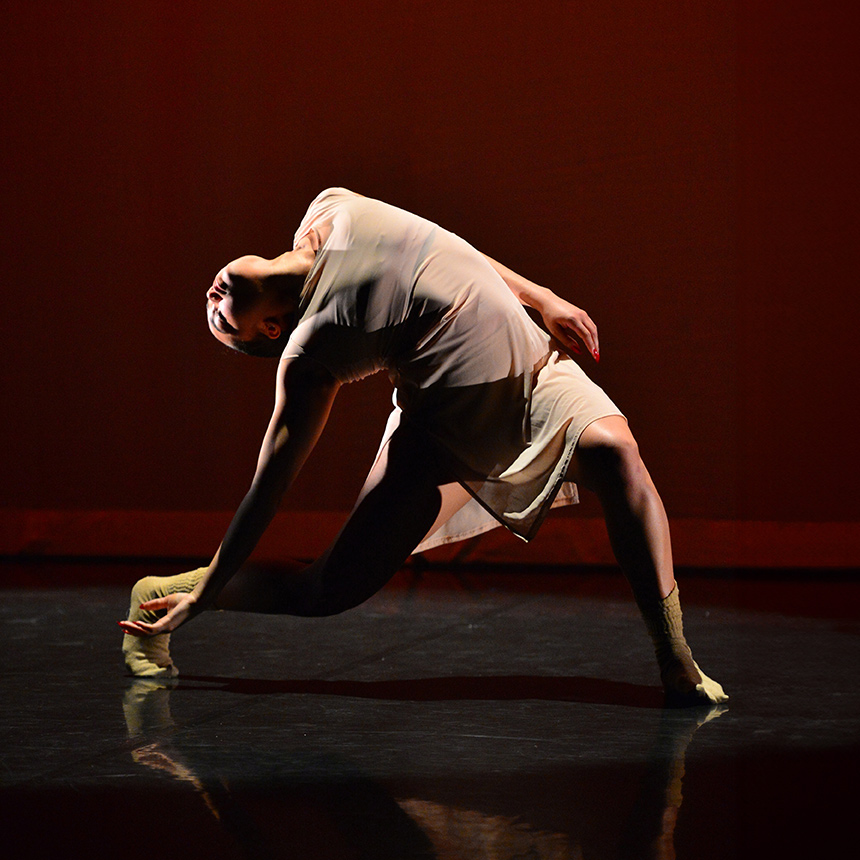 A modern dancer gracefully bends backward during a performance