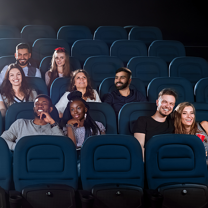 Smiling audience members in a movie theater