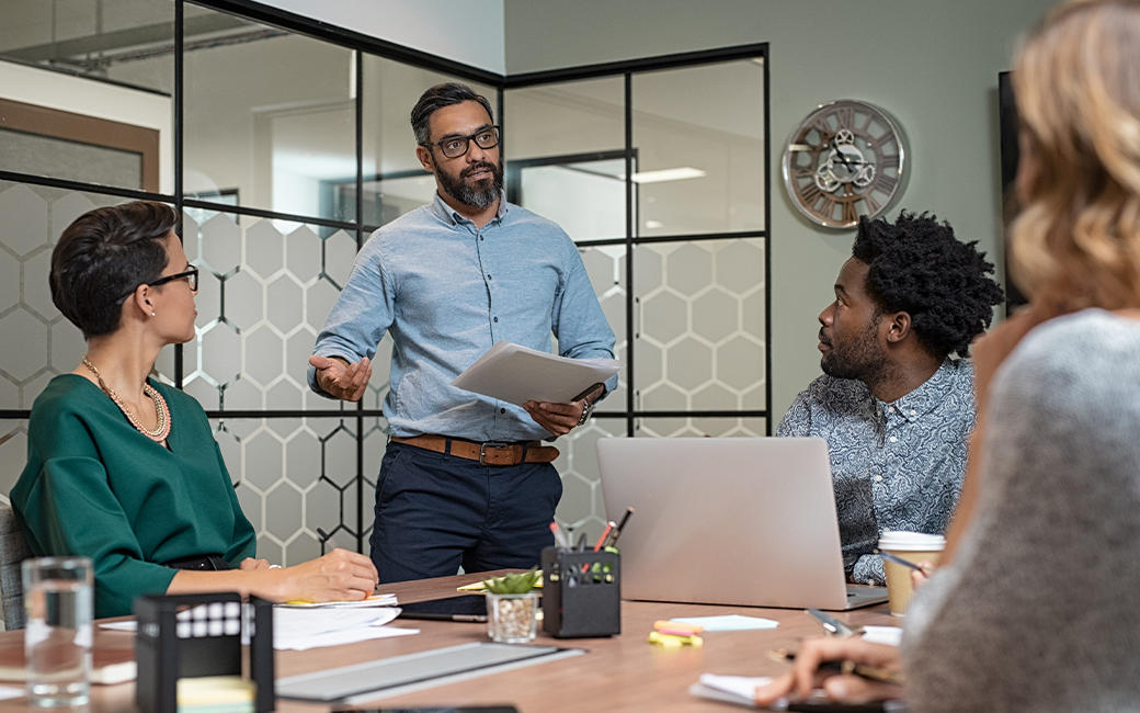 A younger man in an office leading a meeting