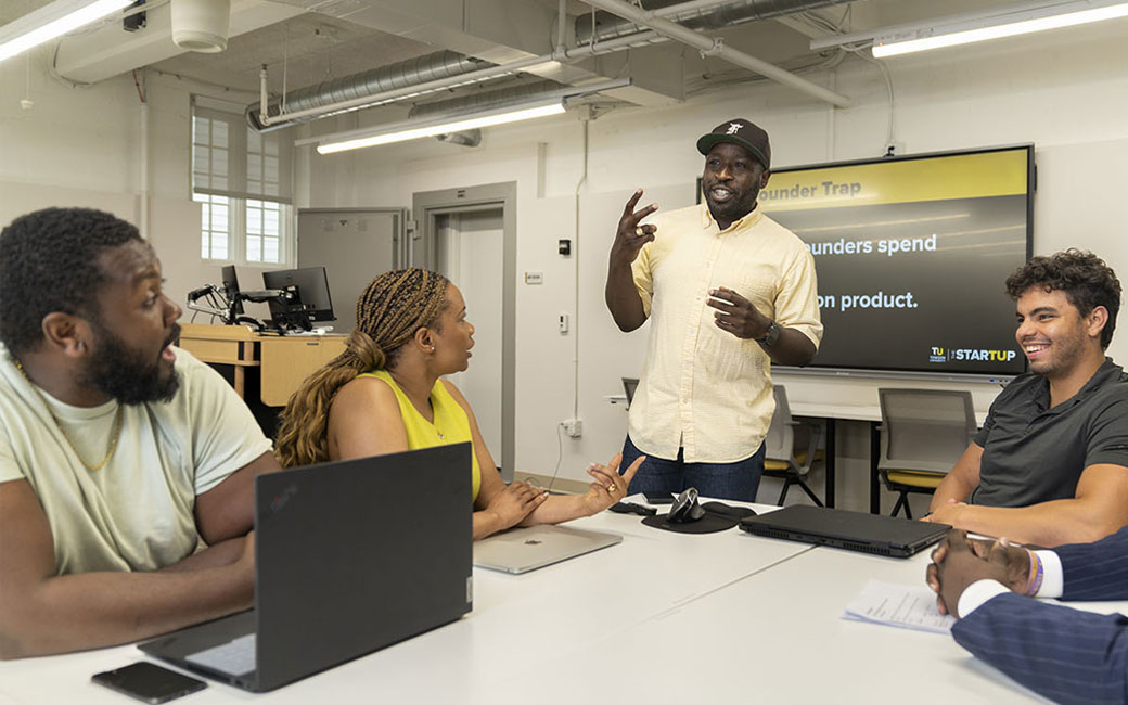 daniel kawah leads discussion with group of three entrepreneurs