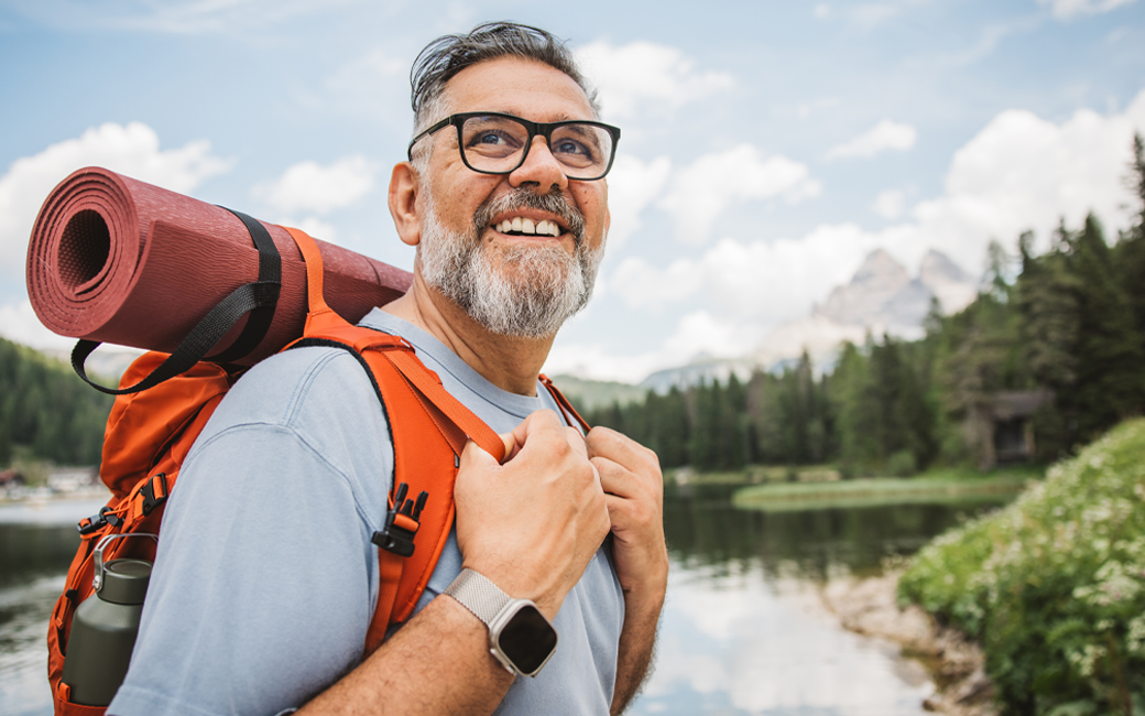 middle aged man backpacking with mountain in background