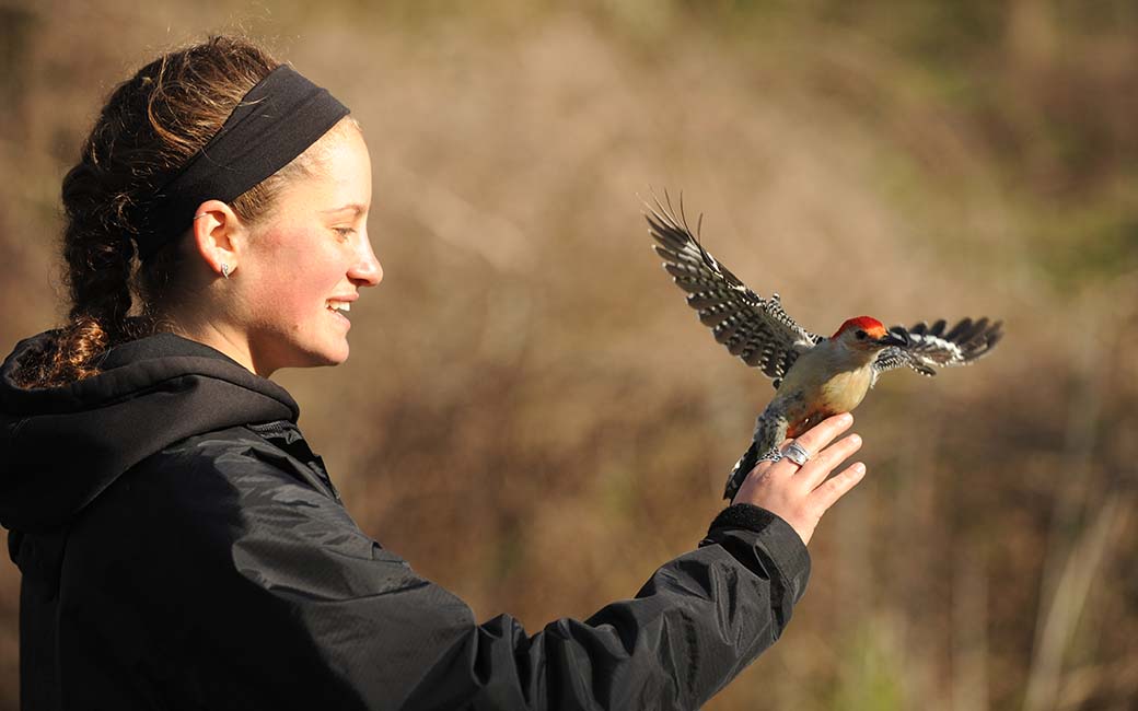 female student holding a bird