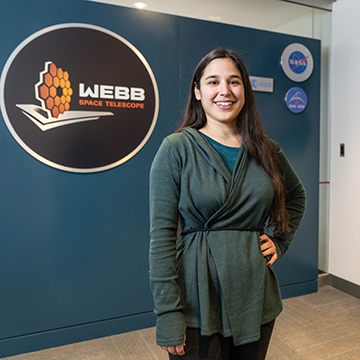 person standing in front of telescope sign