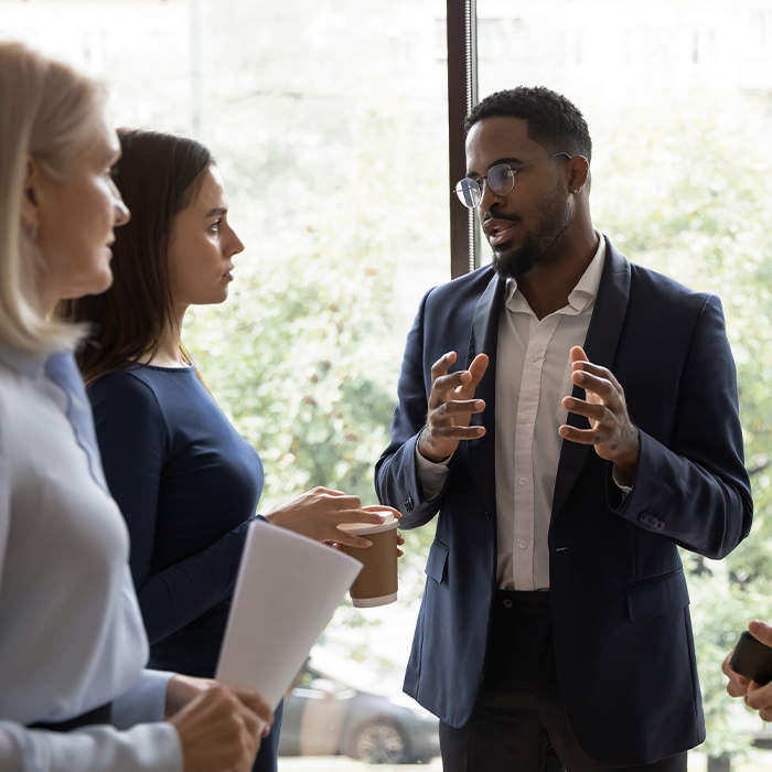 A black man in a suit leading a meeting