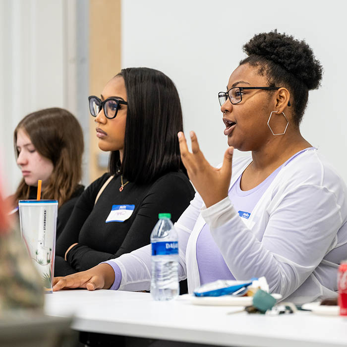 Students talking animatedly at a desk