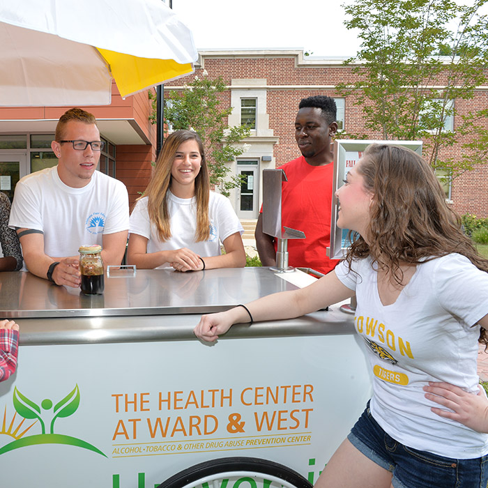 Students around wellness cart, smiling and looking at each other