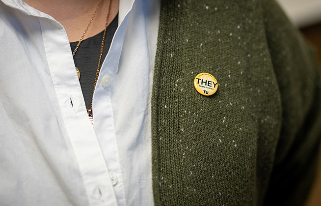 Pronoun pin on the lapel of a sports coat