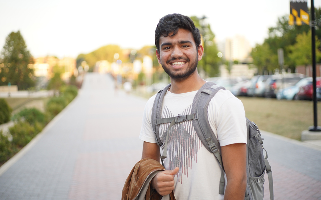 Student standing on campus with backpack