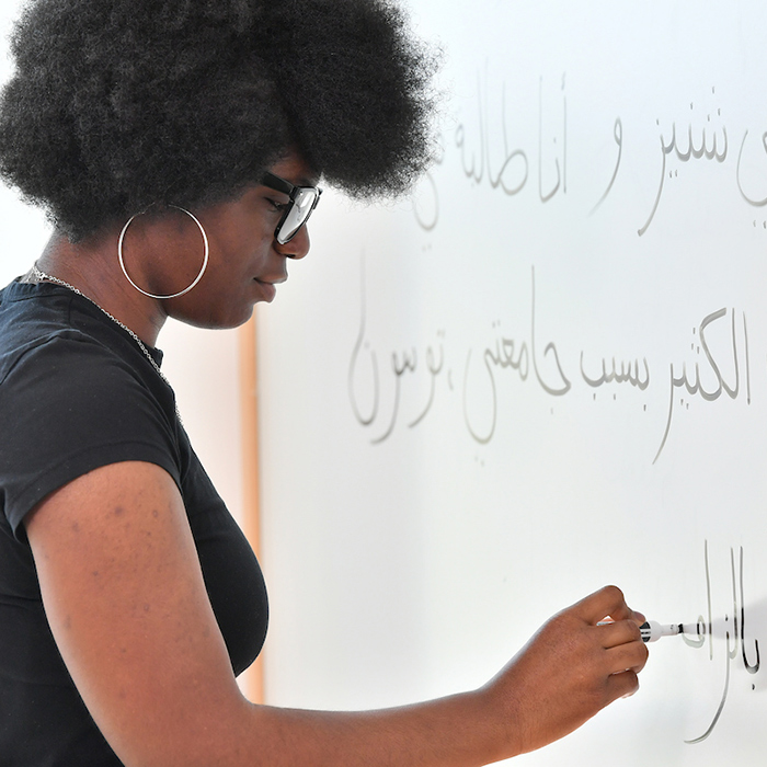 Student writing at whiteboard