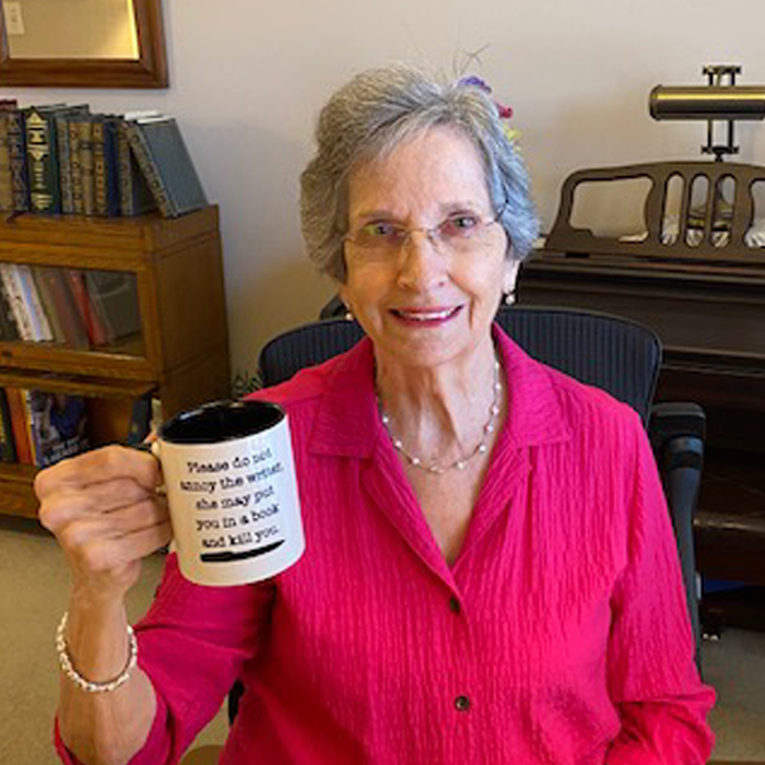 Peggy Rowe at home holding a coffee cup