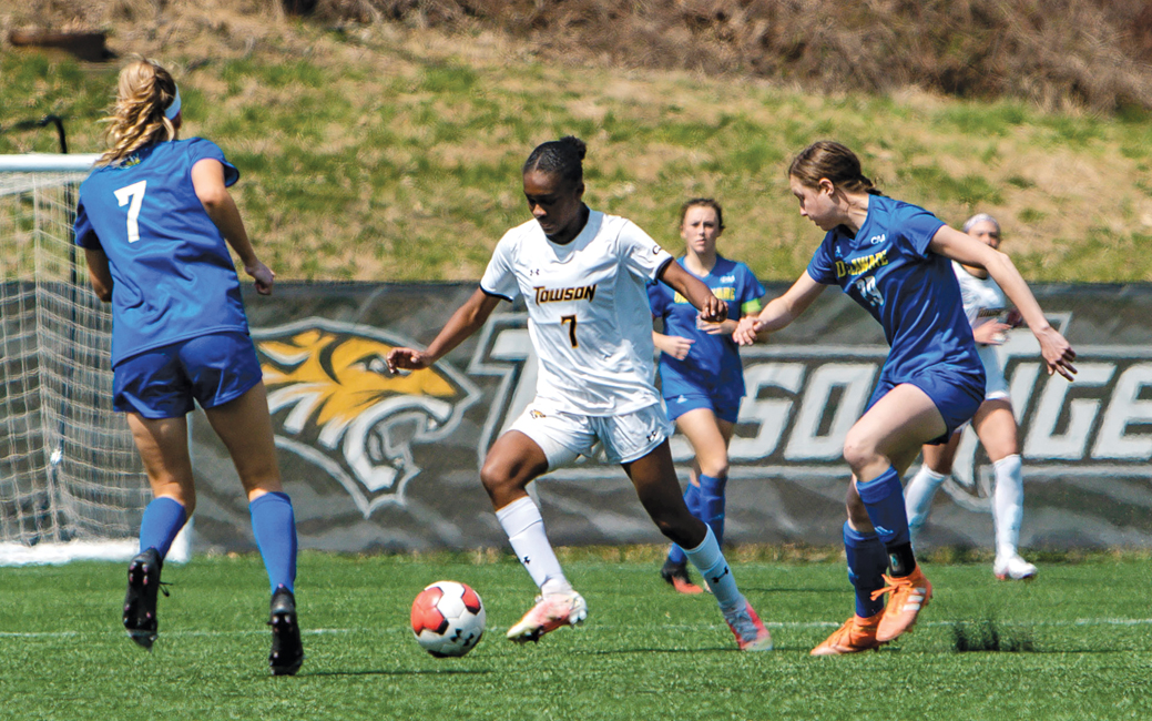 Photo of three women's soccer players in action on the field