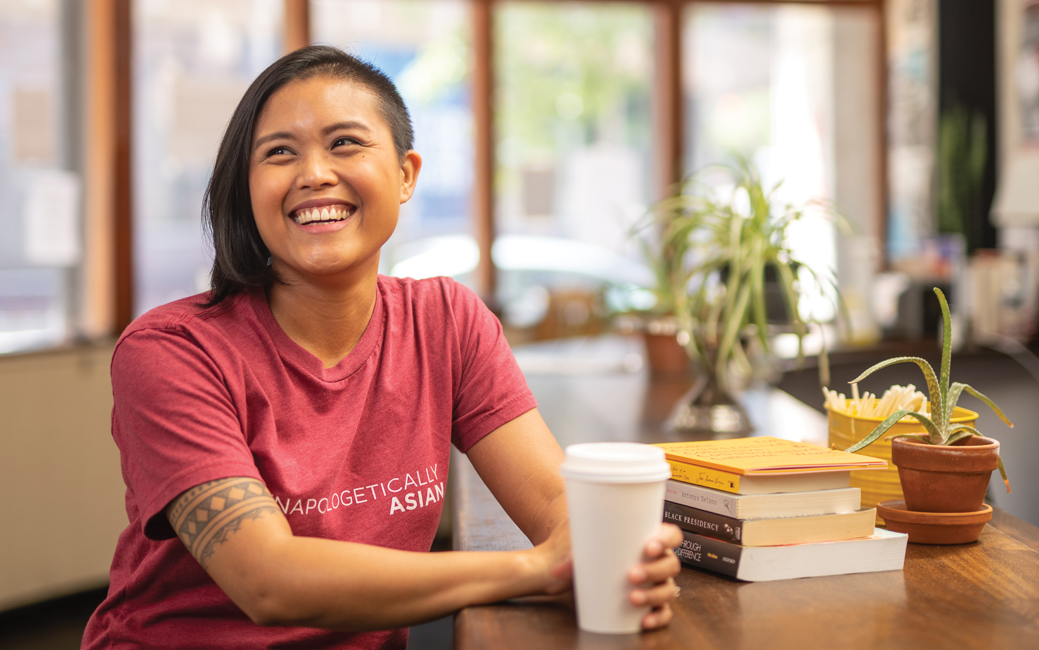 Cori Dioquino seated at a table in a coffee shop