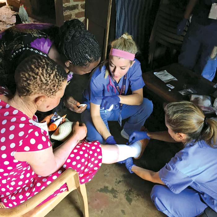 group of people wrapping a bandage around a leg