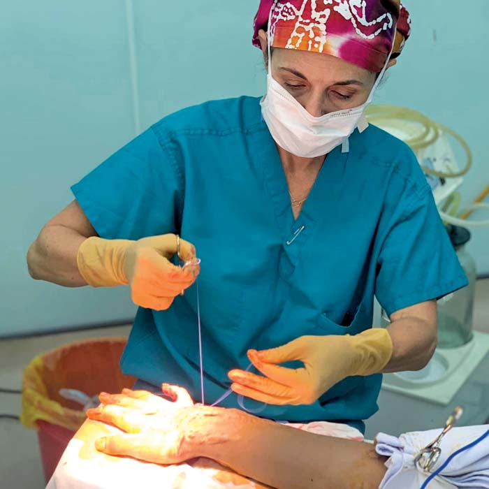 Steffens sewing a patient's arm