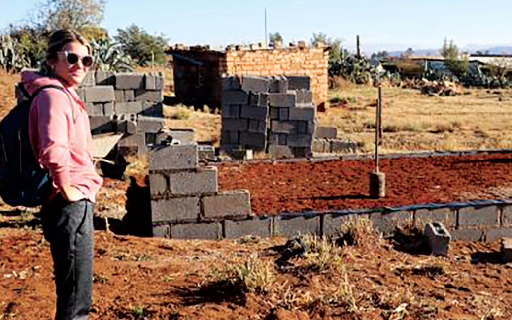 Lauren Snyder in front of a house foundation in Africa